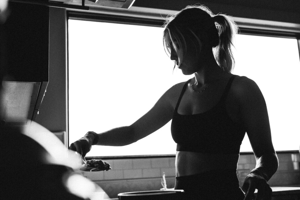 A woman standing in a kitchen next to a window